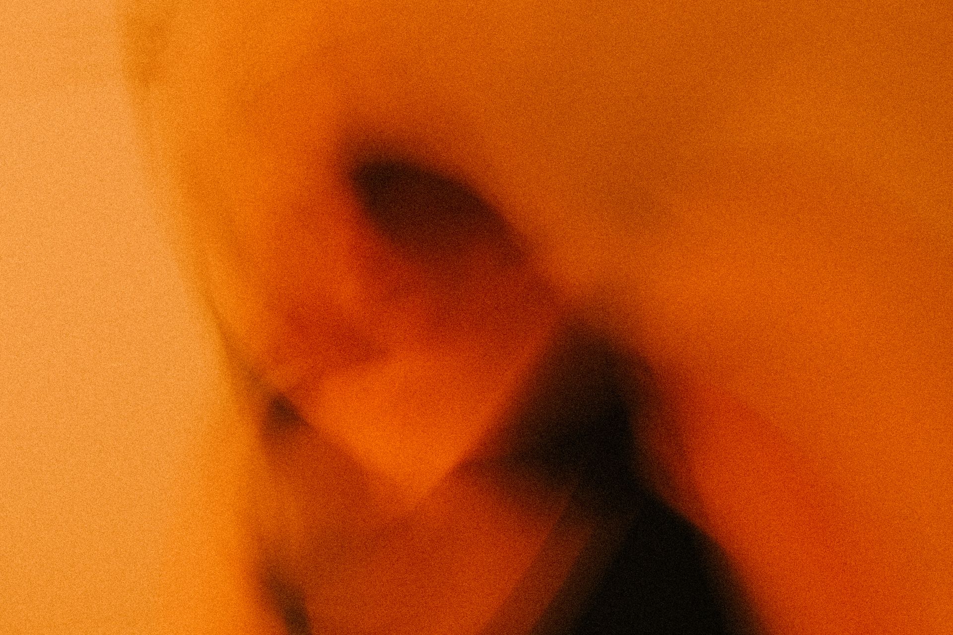 A figure in blurred motion against darkness